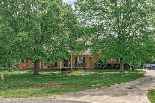 612 Kari Crk, Bossier City, LA 71111 - obstructed view of property featuring driveway, a front yard, covered porch, and brick siding