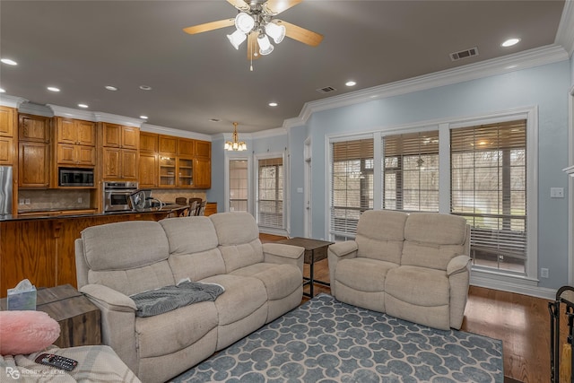 living area featuring crown molding, visible vents, wood finished floors, and recessed lighting