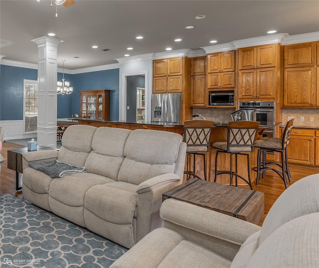 612 Kari Crk, Bossier City, LA 71111 - living room featuring wood finished floors, a notable chandelier, ornate columns, and crown molding