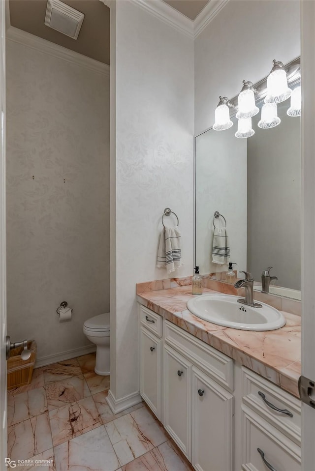 bathroom featuring baseboards, toilet, ornamental molding, marble finish floor, and vanity