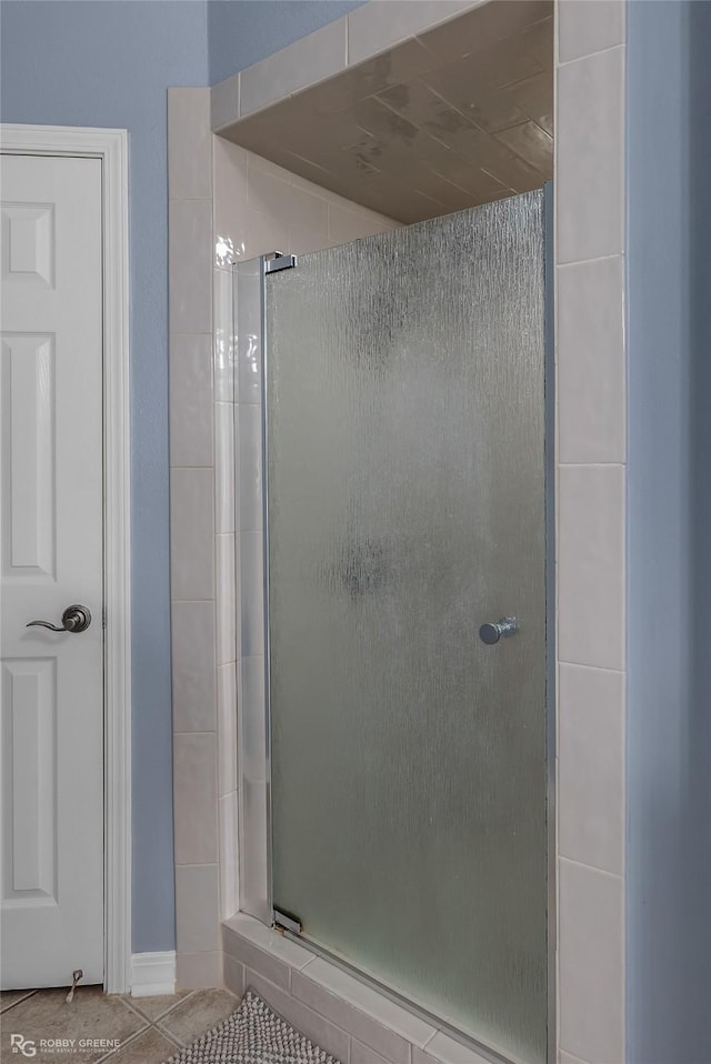 bathroom with a stall shower and tile patterned floors