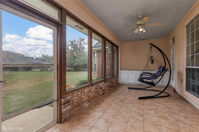 unfurnished sunroom with ceiling fan