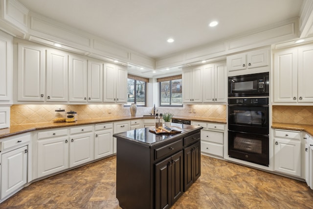 kitchen with white cabinets, decorative backsplash, black appliances, a sink, and recessed lighting