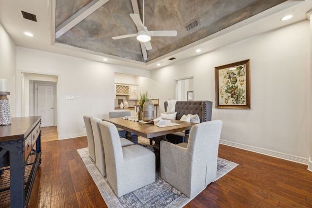 dining room with a raised ceiling, visible vents, baseboards, and hardwood / wood-style floors