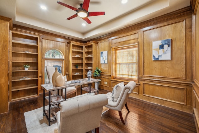 home office with ceiling fan, a tray ceiling, and dark wood-type flooring