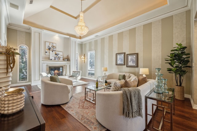 living area with dark wood-type flooring, a tray ceiling, a premium fireplace, and wallpapered walls