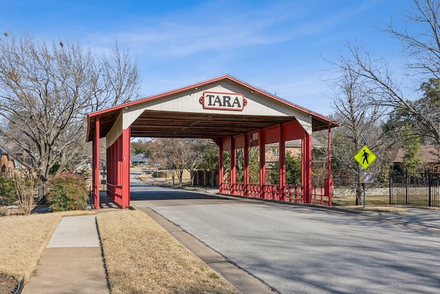 exterior space with fence, aphalt driveway, and a carport