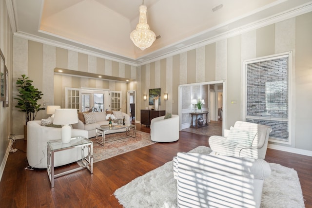 living area with a chandelier, wood finished floors, baseboards, ornamental molding, and wallpapered walls