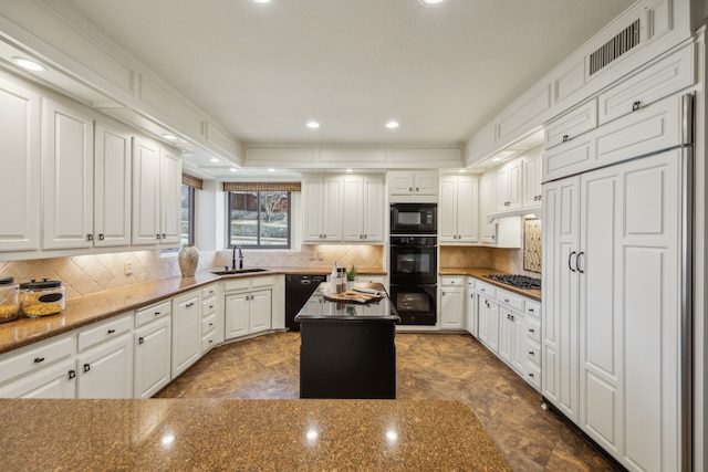 kitchen featuring tasteful backsplash, visible vents, a sink, and black appliances