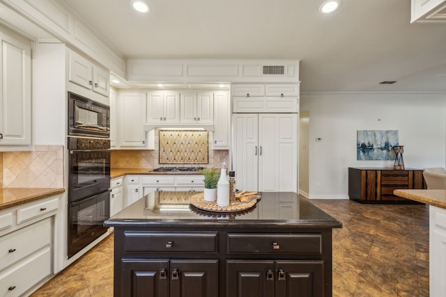 kitchen with visible vents, white cabinetry, backsplash, and black appliances