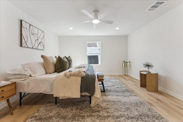 bedroom with light wood finished floors, recessed lighting, visible vents, and baseboards