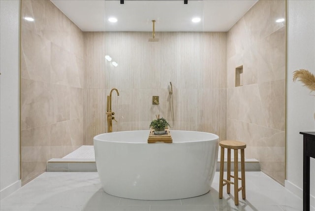 full bath with a freestanding tub, a walk in shower, tile walls, and tile patterned floors