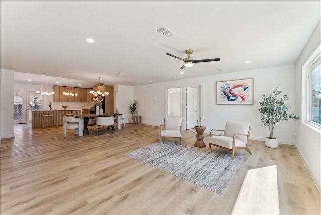 living area featuring baseboards, light wood-style flooring, visible vents, and recessed lighting