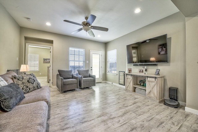 living area featuring recessed lighting, ceiling fan, light wood-style flooring, and baseboards