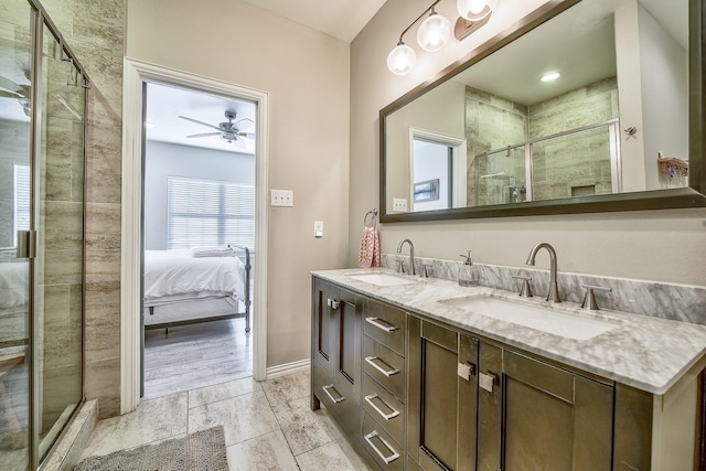 ensuite bathroom featuring double vanity, a stall shower, a ceiling fan, and a sink