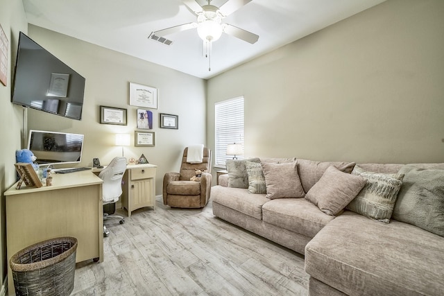 home office with visible vents, light wood finished floors, and a ceiling fan