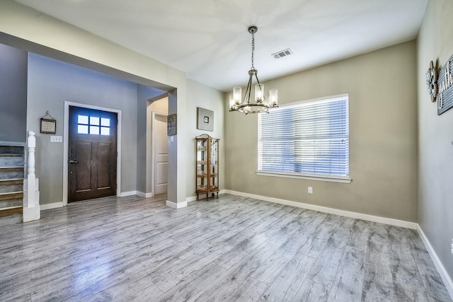 entryway with baseboards, visible vents, stairway, wood finished floors, and a notable chandelier