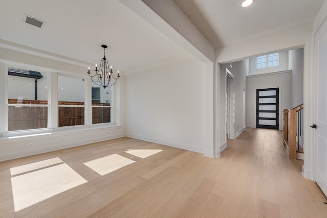 interior space featuring light wood-style floors, visible vents, a notable chandelier, and baseboards