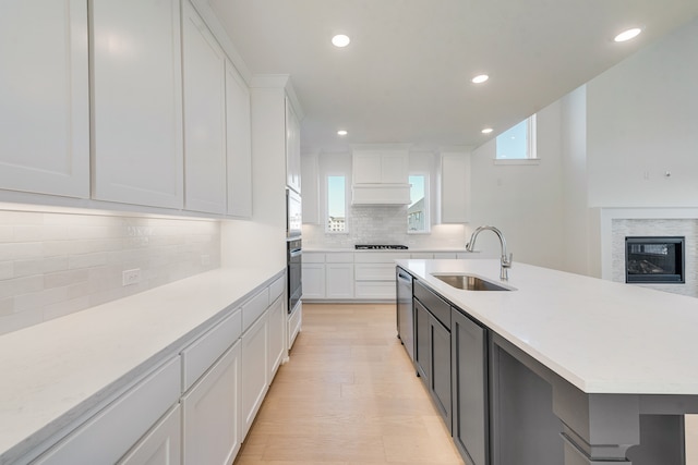 kitchen featuring white cabinetry, light countertops, and a sink