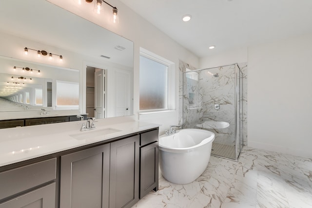 full bathroom with marble finish floor, a marble finish shower, a freestanding bath, and vanity