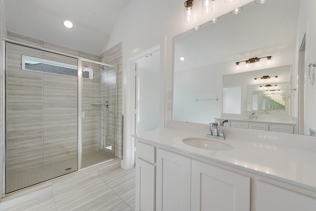 bathroom with lofted ceiling, tile patterned floors, a shower stall, and vanity