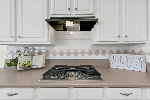 kitchen with white cabinetry, stainless steel gas stovetop, backsplash, and ventilation hood