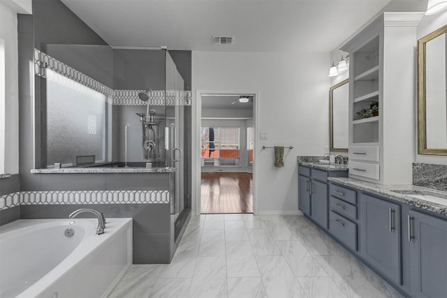 ensuite bathroom with marble finish floor, a garden tub, double vanity, a stall shower, and a sink