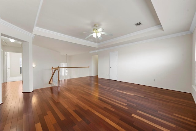 spare room with visible vents, hardwood / wood-style flooring, ceiling fan, ornamental molding, and a tray ceiling