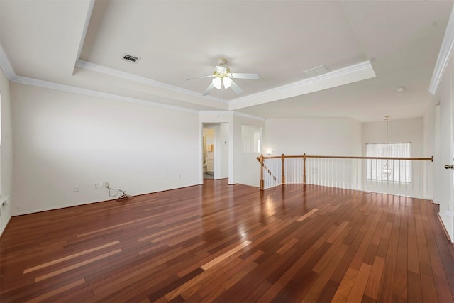 unfurnished room with crown molding, visible vents, a raised ceiling, and hardwood / wood-style floors