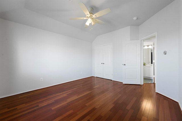 unfurnished bedroom featuring dark wood-style floors, lofted ceiling, a closet, and a ceiling fan