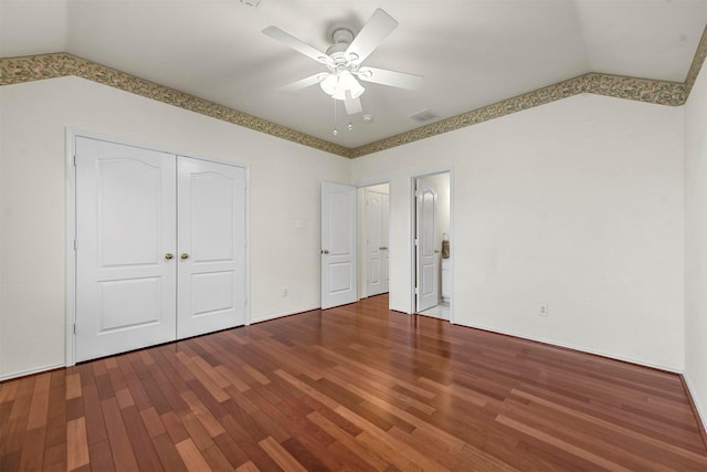 unfurnished bedroom featuring wood finished floors, visible vents, a ceiling fan, vaulted ceiling, and a closet