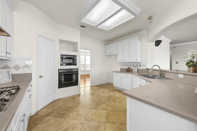 kitchen featuring black appliances, backsplash, a sink, and visible vents