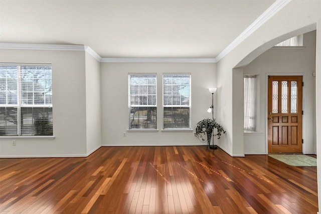 entrance foyer featuring arched walkways, hardwood / wood-style floors, and plenty of natural light