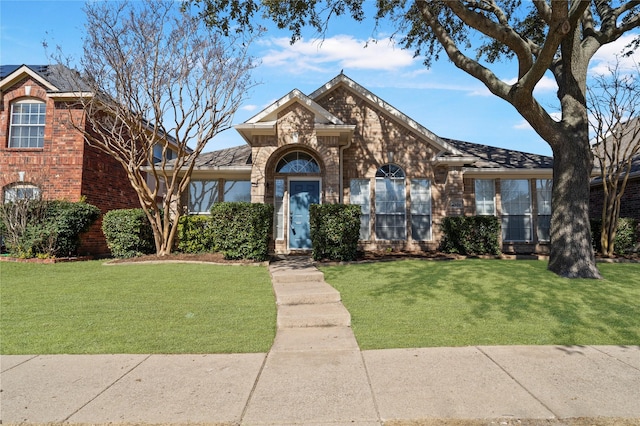 view of front of home with a front lawn and brick siding