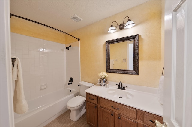 bathroom featuring a textured ceiling, toilet, vanity, visible vents, and washtub / shower combination