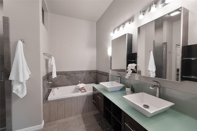 full bathroom with double vanity, a garden tub, tile patterned flooring, and a sink