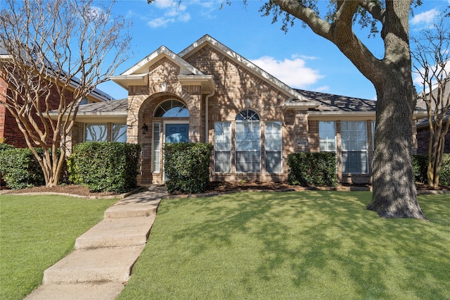 view of front of home featuring a front yard and brick siding