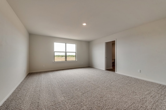 empty room featuring carpet flooring and baseboards