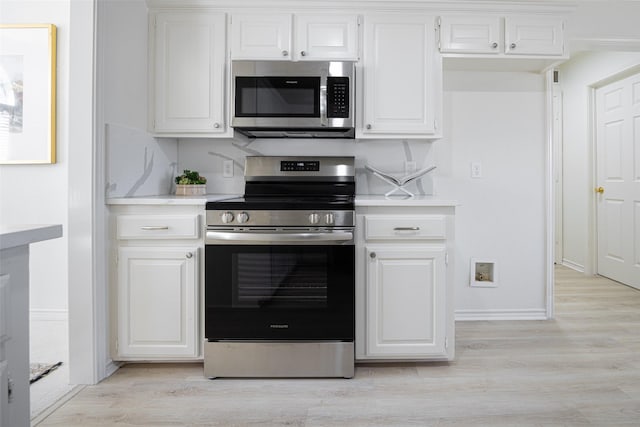 kitchen with appliances with stainless steel finishes, light countertops, and light wood finished floors