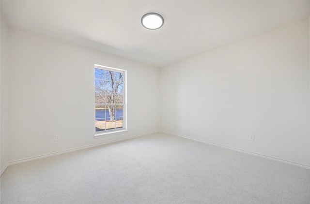 empty room featuring carpet flooring and baseboards