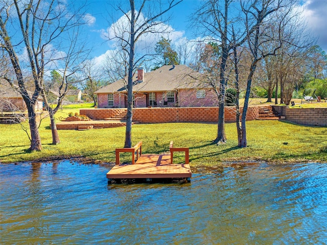 view of dock featuring a water view and a yard