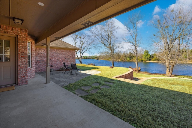 view of yard featuring a water view and a patio