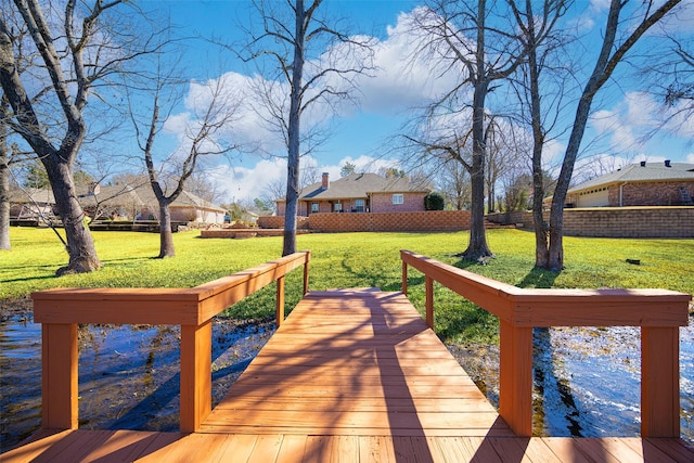 view of dock featuring fence and a lawn