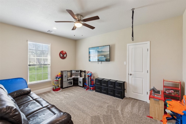 game room featuring baseboards, carpet flooring, visible vents, and a ceiling fan