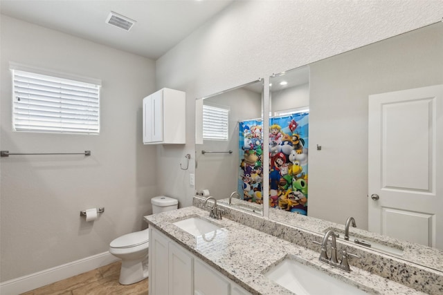 full bath featuring baseboards, visible vents, a sink, and toilet