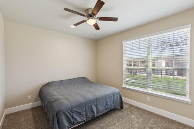 carpeted bedroom with ceiling fan and baseboards