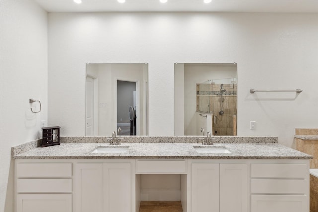 full bath featuring double vanity, a shower stall, a sink, and recessed lighting