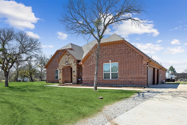 view of front of property with a garage, driveway, brick siding, and a front lawn