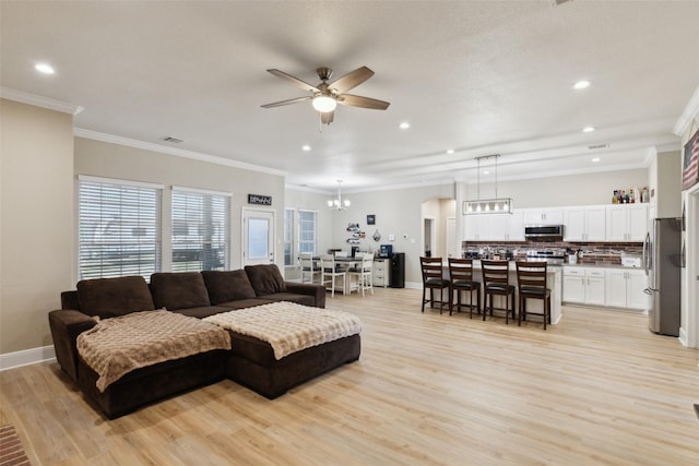 living room featuring light wood-style floors, baseboards, visible vents, and ceiling fan with notable chandelier