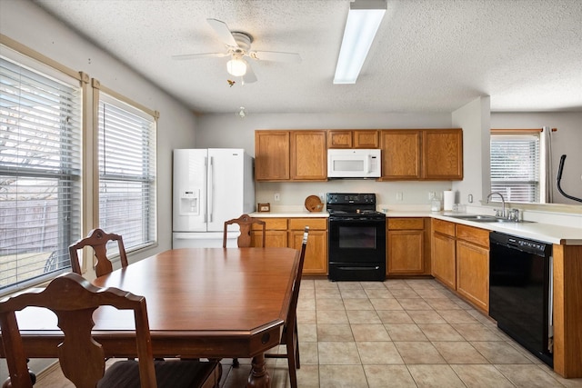 kitchen featuring light tile patterned floors, brown cabinetry, light countertops, black appliances, and a sink